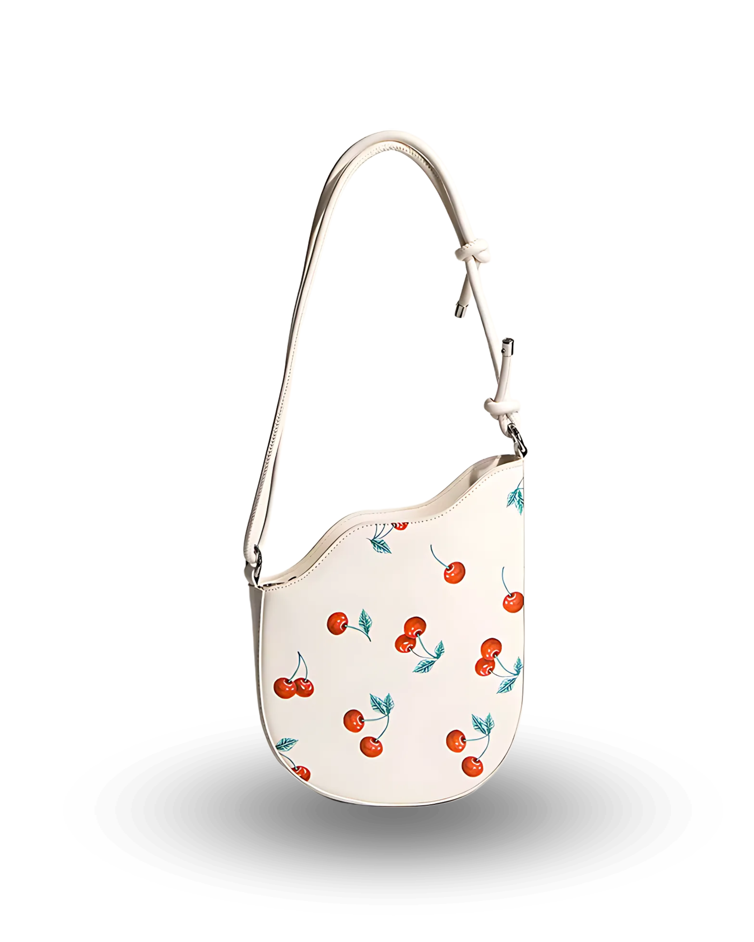 White shoulder bag with playful red cherry print, curved top edge, and adjustable strap with knotted detail