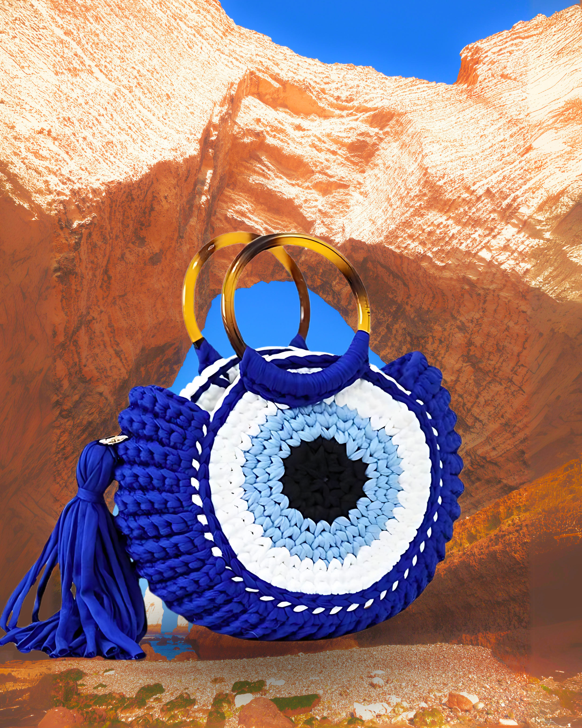 Round woven crochet handbag with layered fan-shaped black edges, evil eye design, and dual circular resin handles and a large matching side tassel. Blue color eye