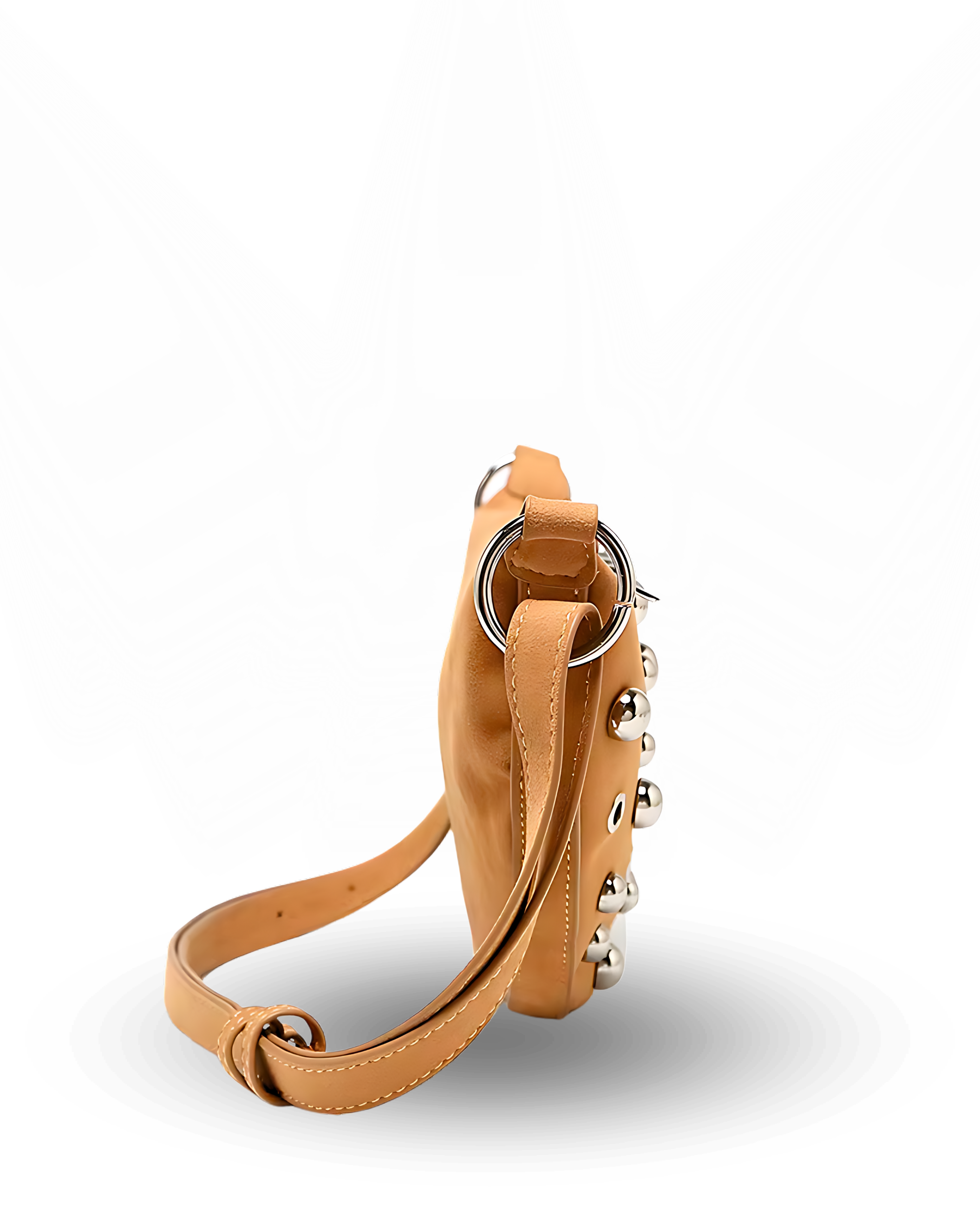 Curved crossbody sling bag made form vegan suede in autumn tan colours with a top zipper closure, adjustable shoulder strap, and metallic studded accents across the front.