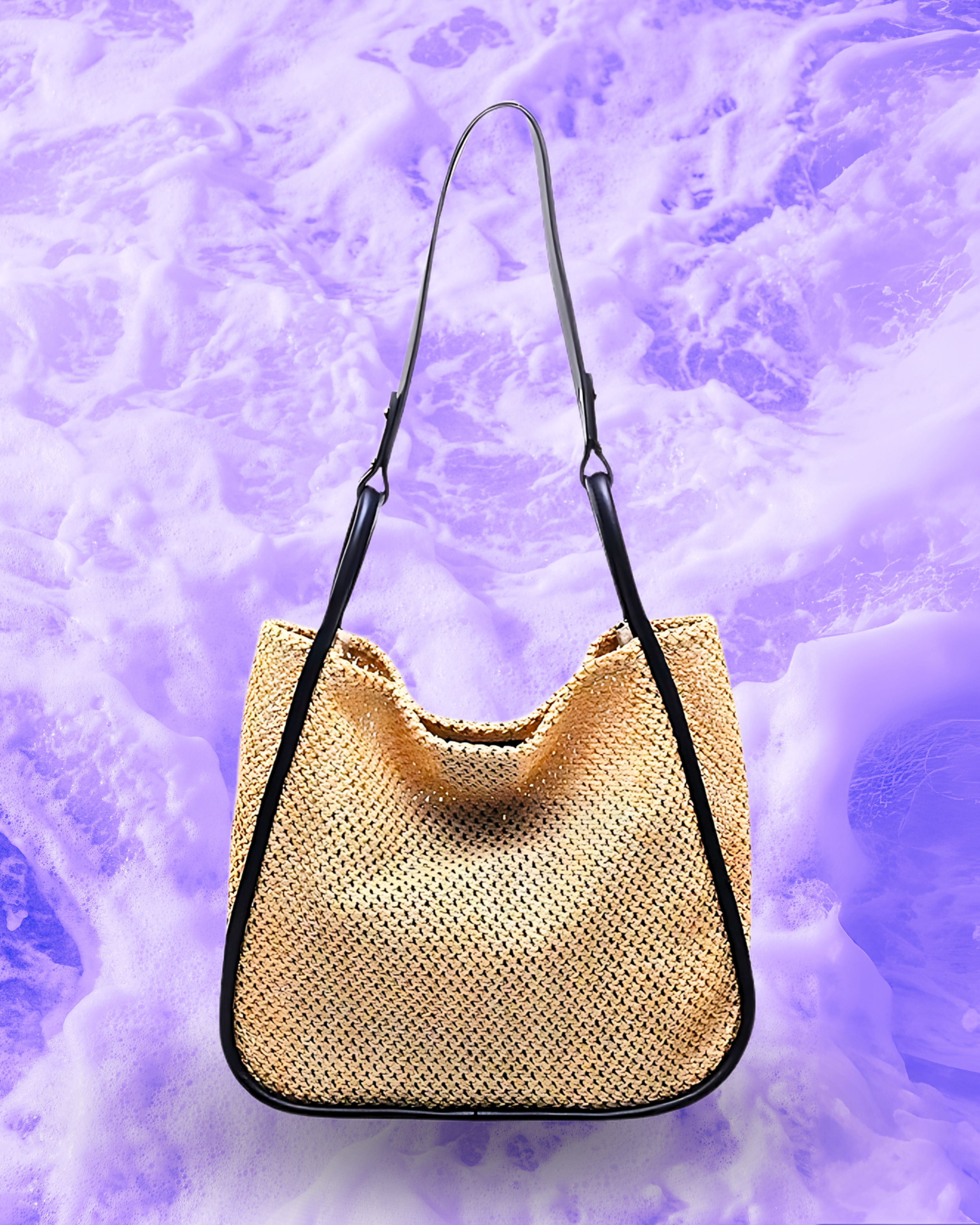 Soft rectangular woven raffia shoulder bag with a slouchy open-top design, long adjustable black leatherette strap, and black contrast trim framing the edges.