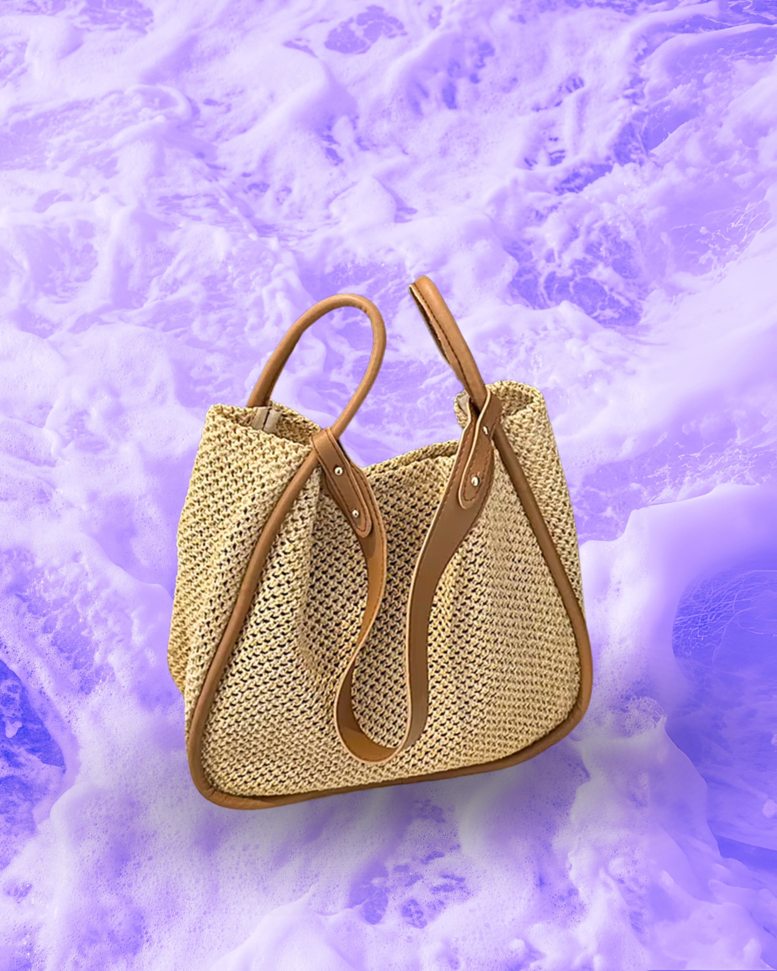 Soft rectangular woven raffia shoulder bag with a slouchy open-top design, long adjustable brown leatherette strap, and brown contrast trim framing the edges.