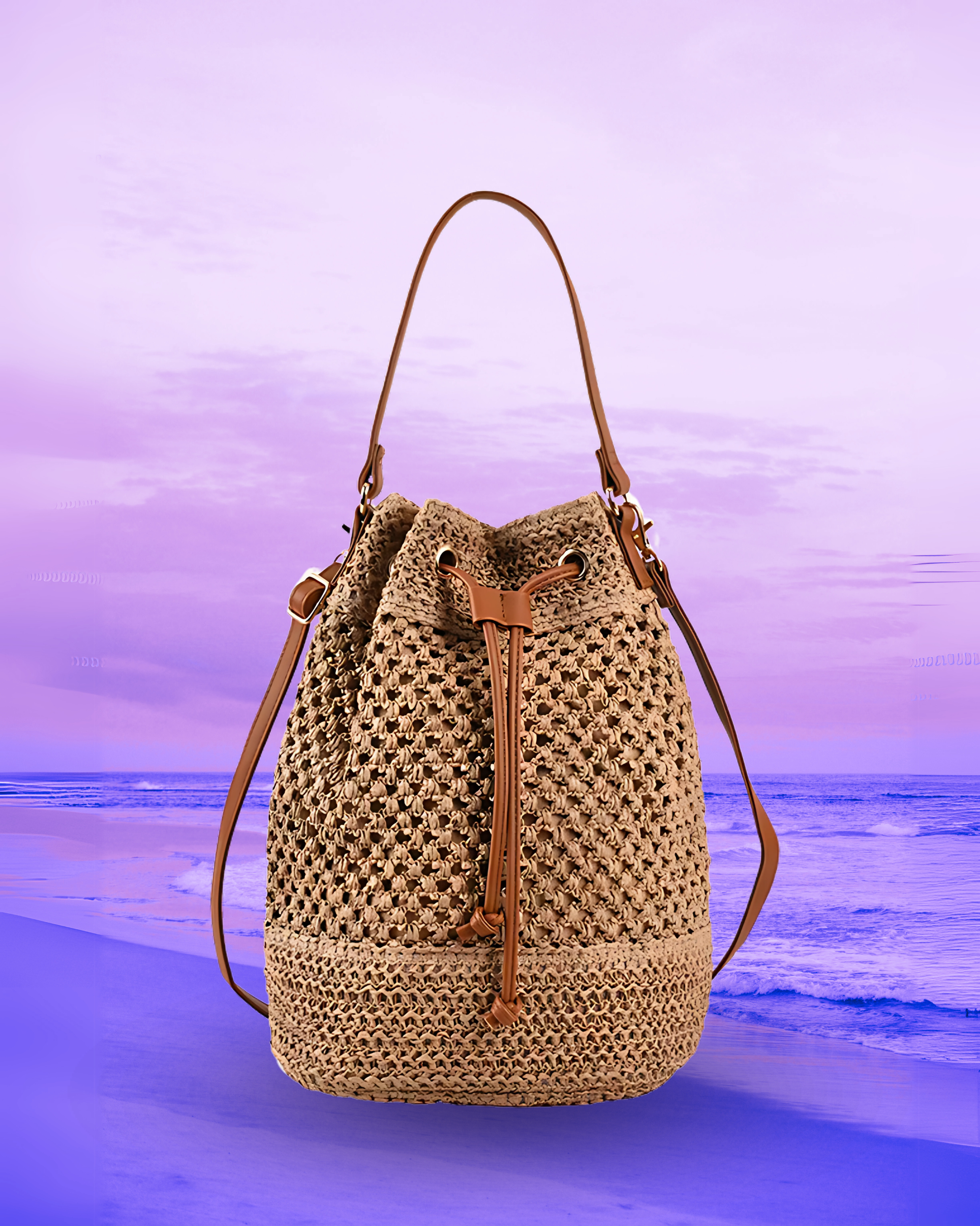 Tall cylindrical woven straw bucket bag with a flat base, open-top drawstring closure, and dual brown leather straps for shoulder or crossbody wear.