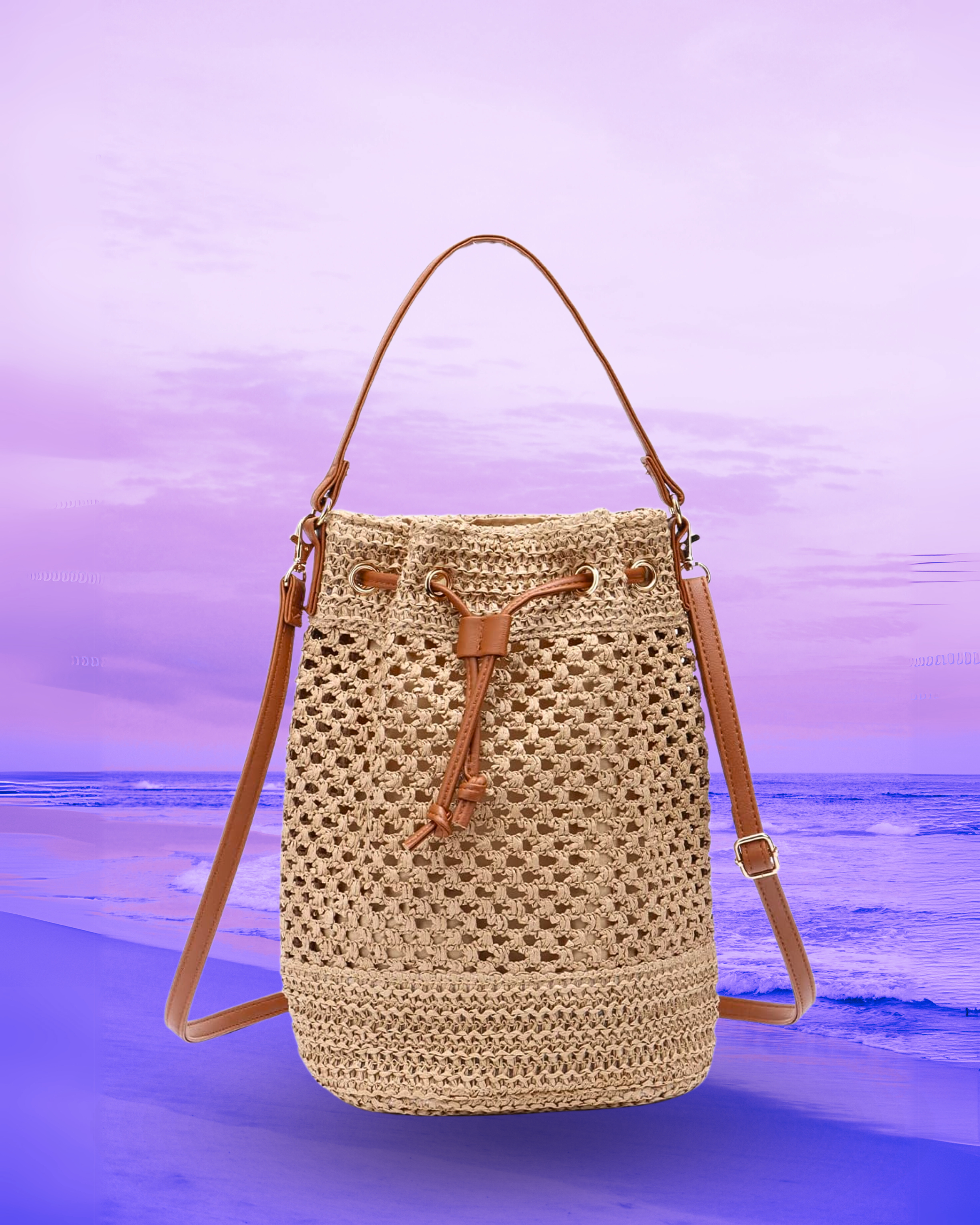 Tall cylindrical woven straw bucket bag with a flat base, open-top drawstring closure, and dual brown leather straps for shoulder or crossbody wear.